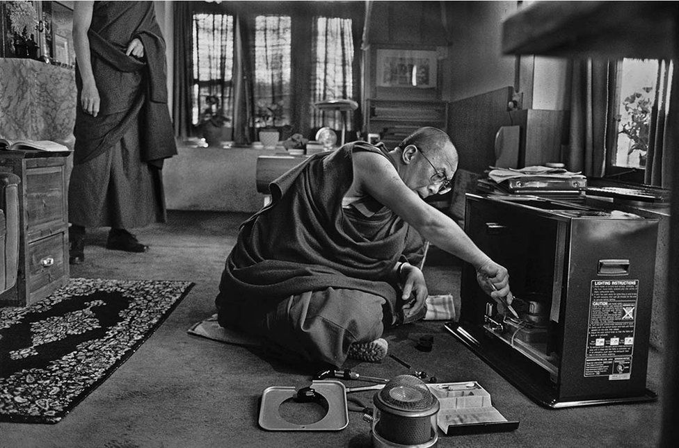 The Dalai Lama repairing the television