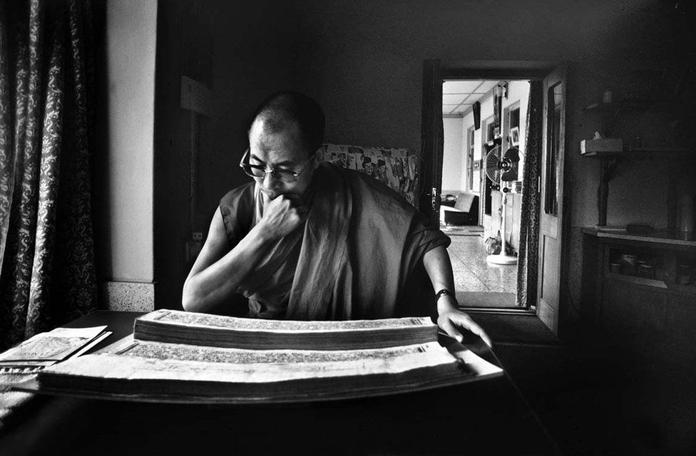 The Dalai Lama reading Tibetan scriptures